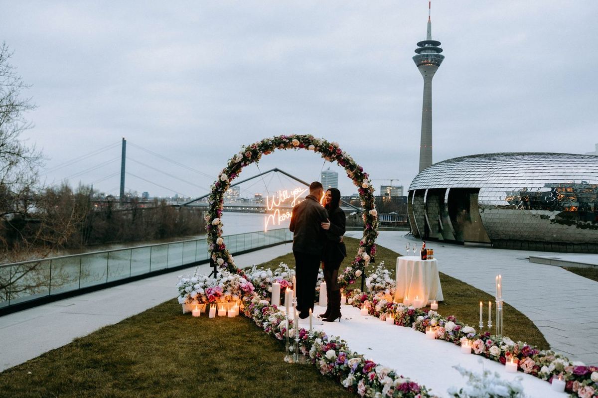 Heiratsantrag Düsseldorf Rooftop rosa Blumenherz Sonnenuntergang