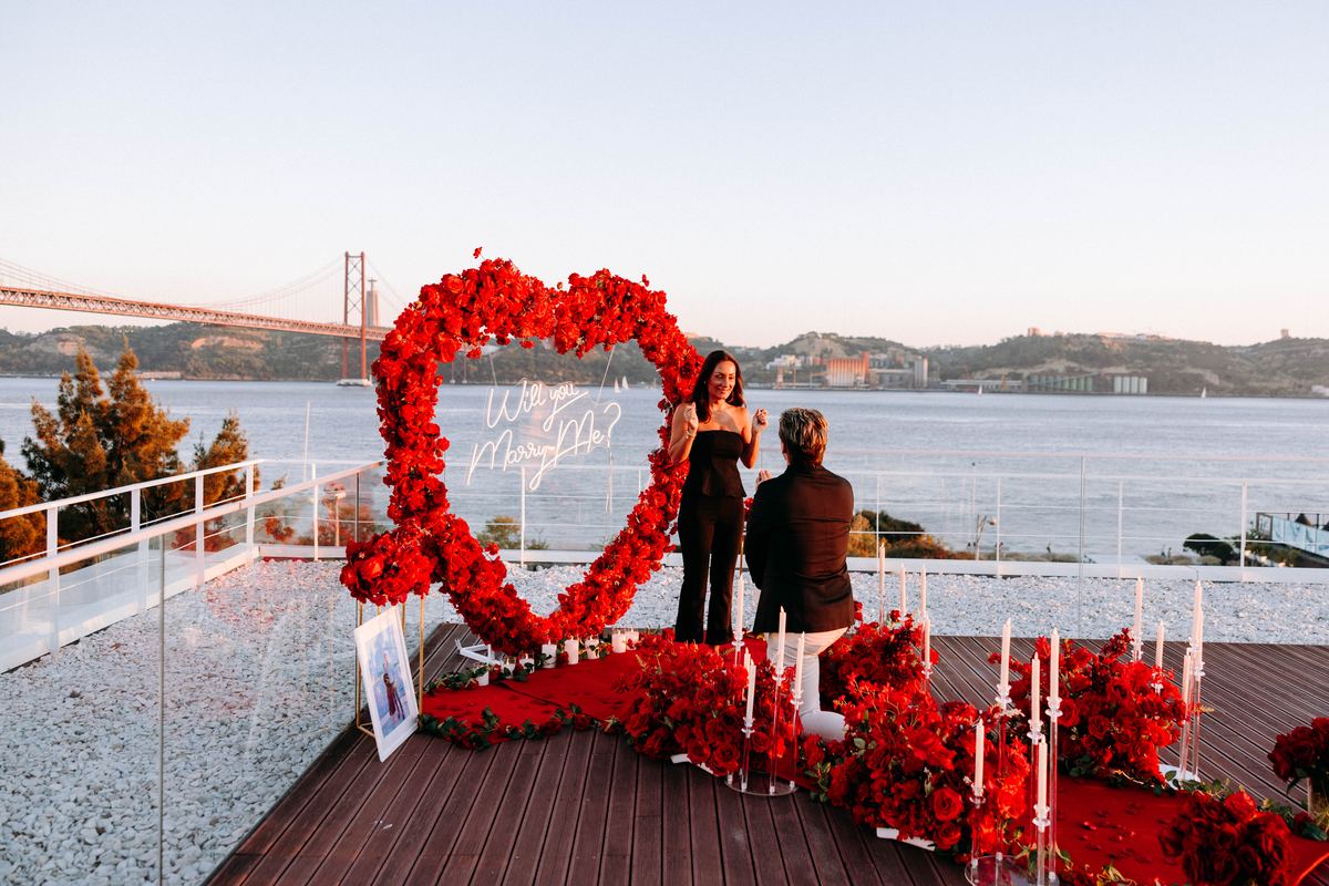 Heiratsantrag Lissabon rotes Blumenherz Brücke Sonnenuntergang